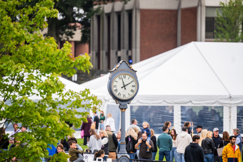 An ornate traditional clock amongst a crowd formed for Friar Fest Homecoming.