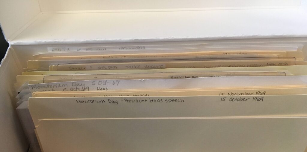 An opened Archives Collections Box filled with labelled folders with various materials.