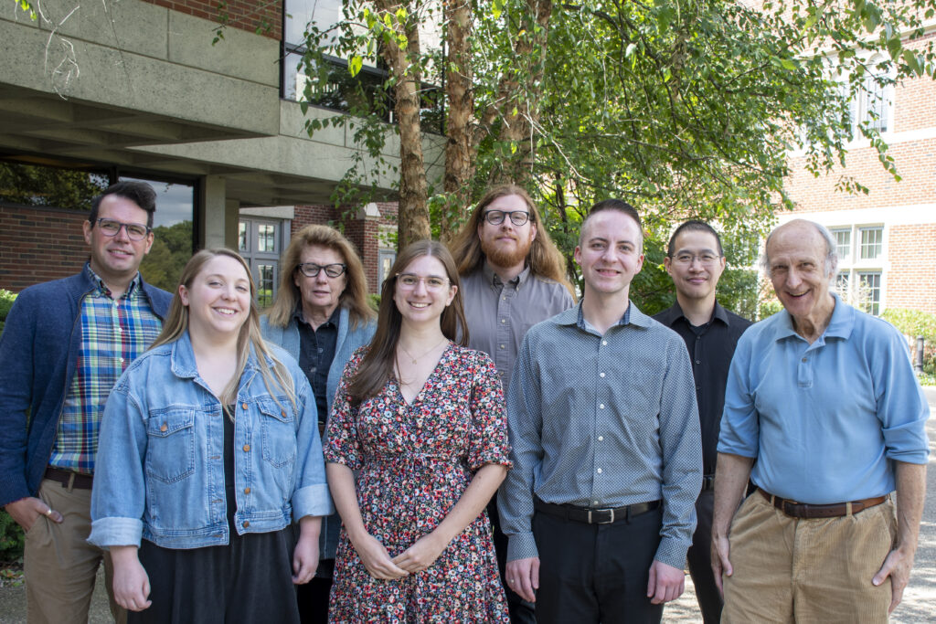 Eight staff members look at camera and smiling at viewer. 