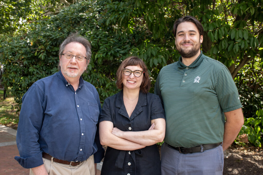 The director, assistant director , and library admin smile looking onwards to the viewer.