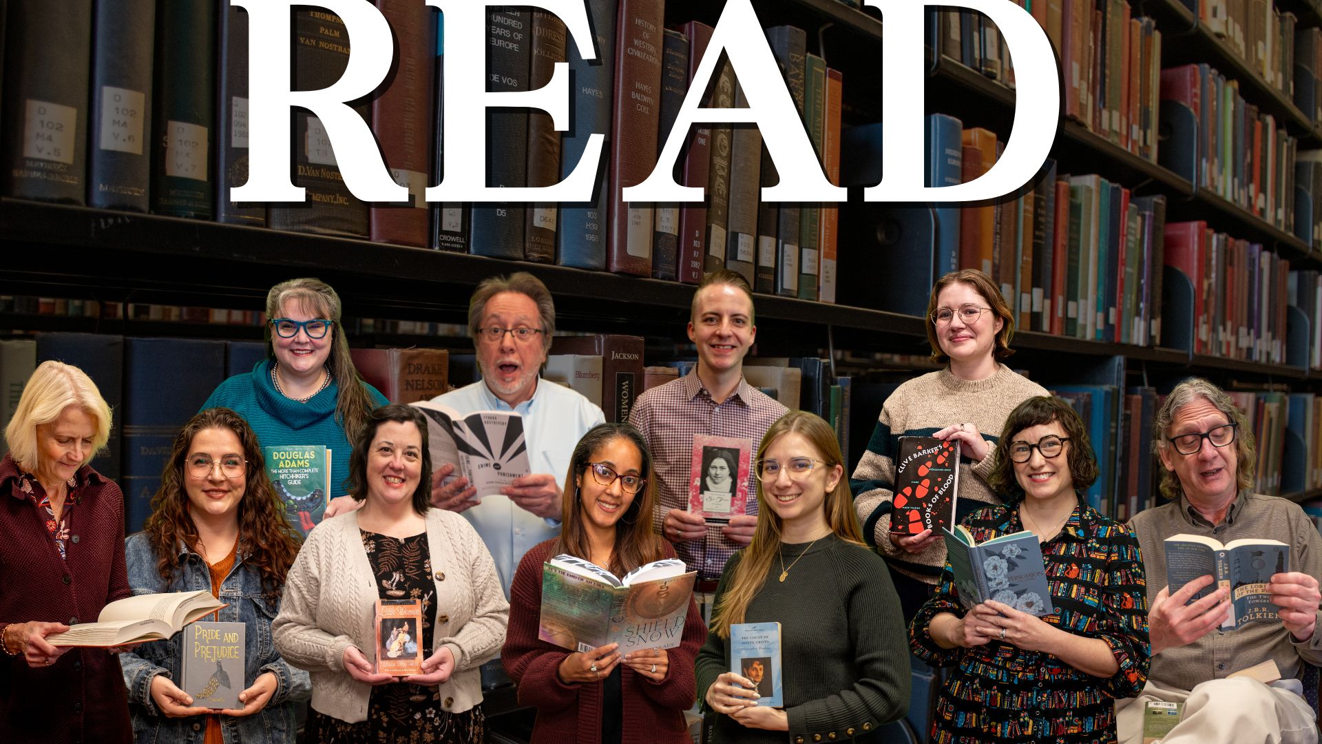 Composite promotional image for the Phillips Memorial Library READ campaign. A group of library faculty and staff stand in front of bookshelves, each holding a favorite book. Large white text across the top reads “READ.” The image includes ten participants arranged in two rows, with a variety of poses and expressions, creating a warm, celebratory portrait of readers and books in the library.