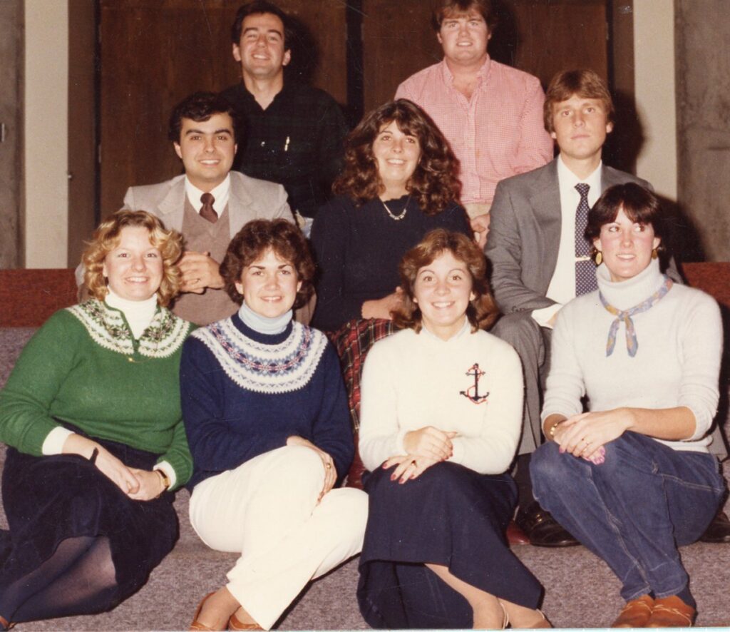 Students sit on stairs for a posted photo.
